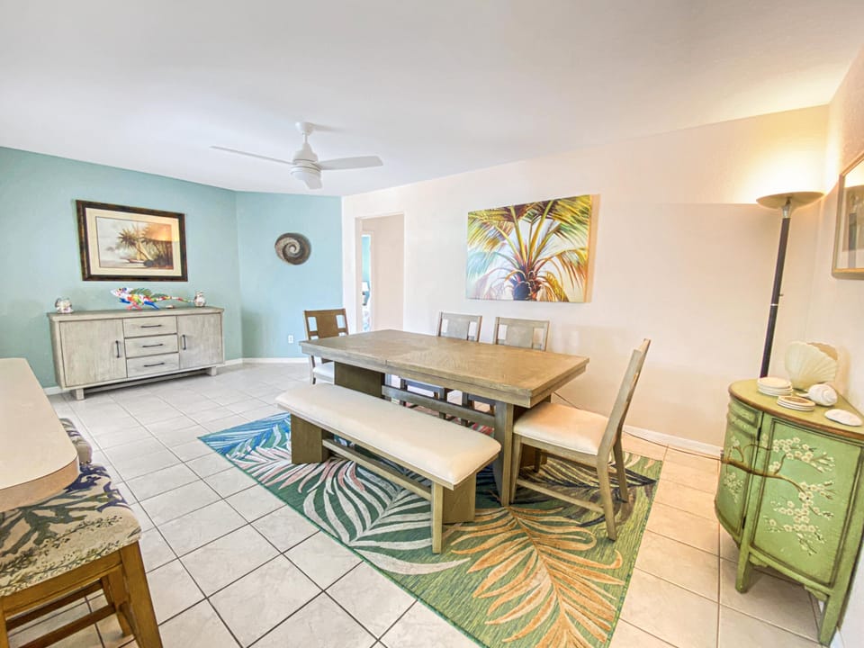 Bright dining area with tropical decor and seating for six, perfect for family meals.