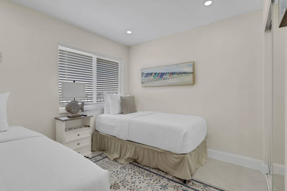 The guest bedroom, at the front of the condo, has a pair of twin beds and a wall mounted Smart TV.