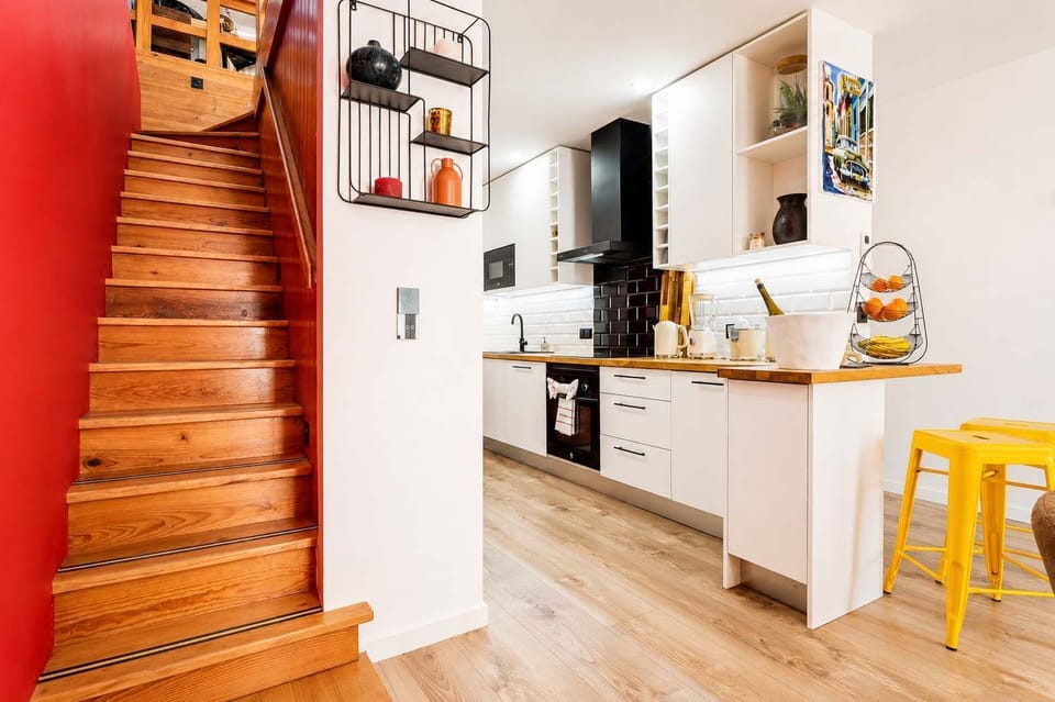 13 · Kitchen with staircase access and bar seating area · StayInLisbon