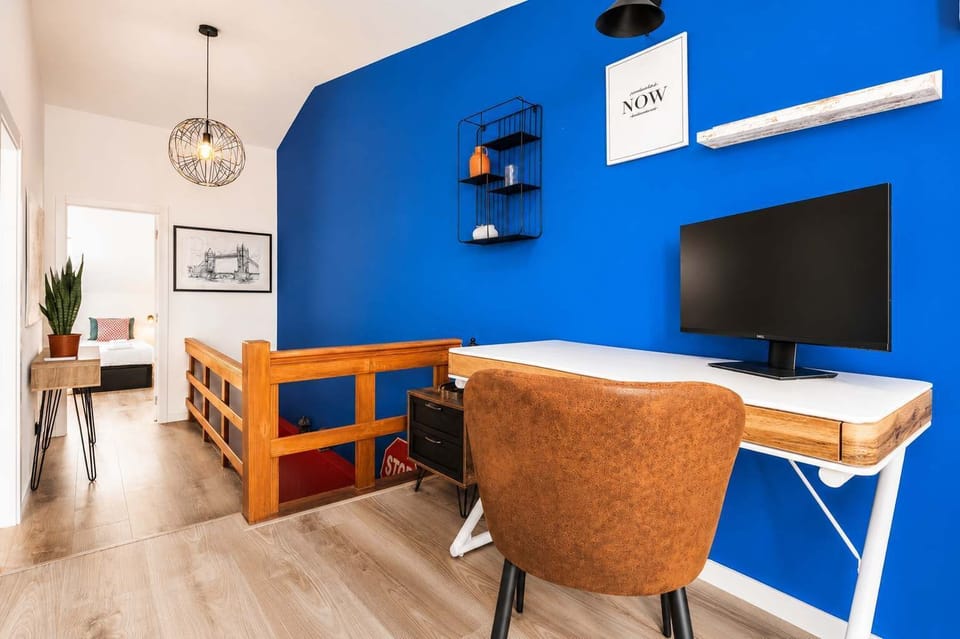 18 · Upper-level workspace desk with shelving and staircase · StayInLisbon