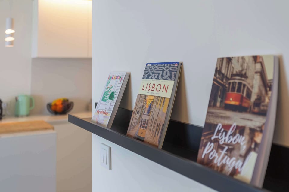 52 · Lisbon-themed reading shelf with open kitchen behind · StayInLisbon