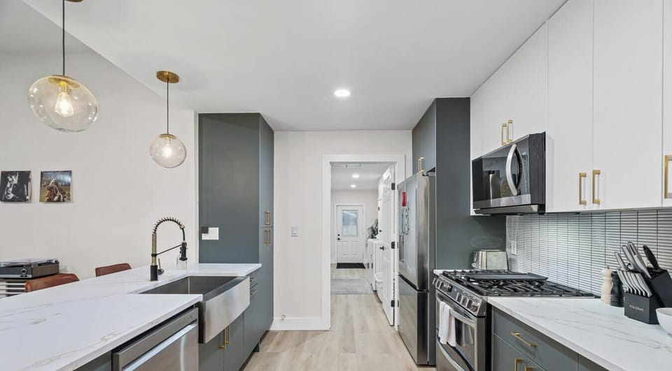 Whip up any meal in the fully equipped kitchen with a farmhouse sink, gold accents, and two-tone cabinetry.