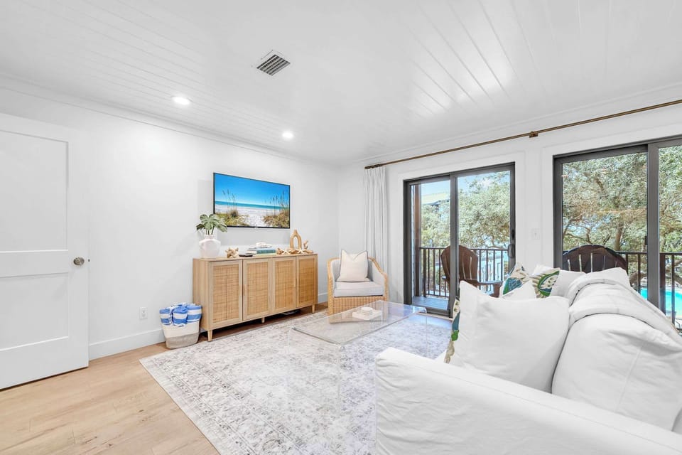 Living room features a sleeper sofa, smart tv, and access to balcony