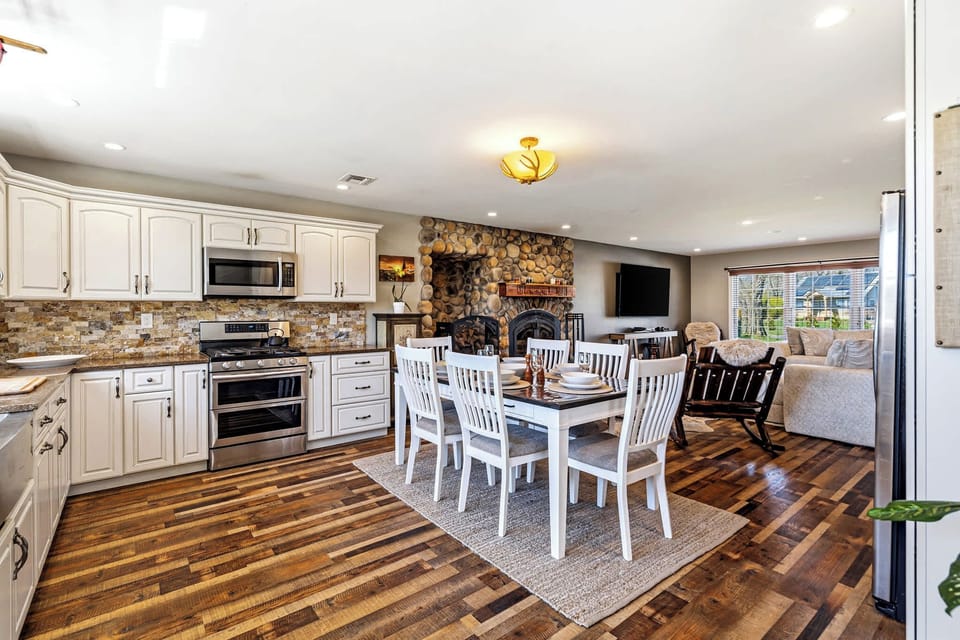 Open-plan kitchen, dining, and living with hardwood floors