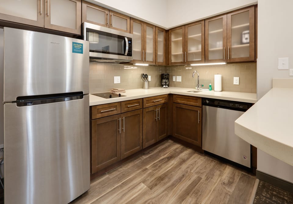 Modern fully equipped kitchen with stainless steel appliances and ample storage.