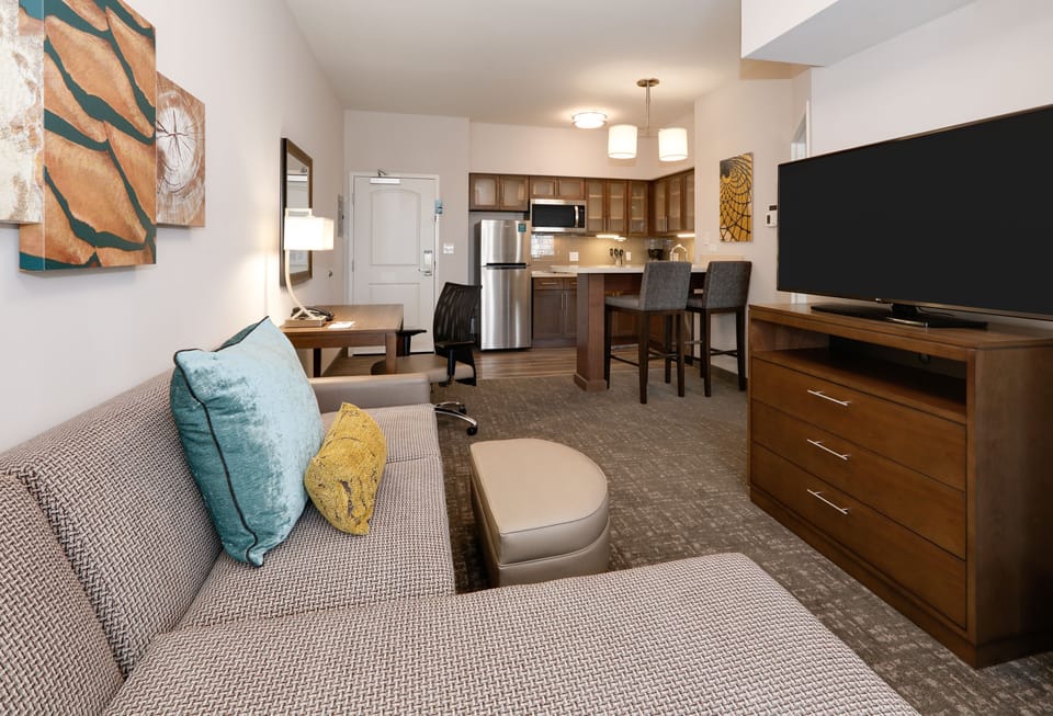 Open living area with sofa, TV, and kitchen dining space.