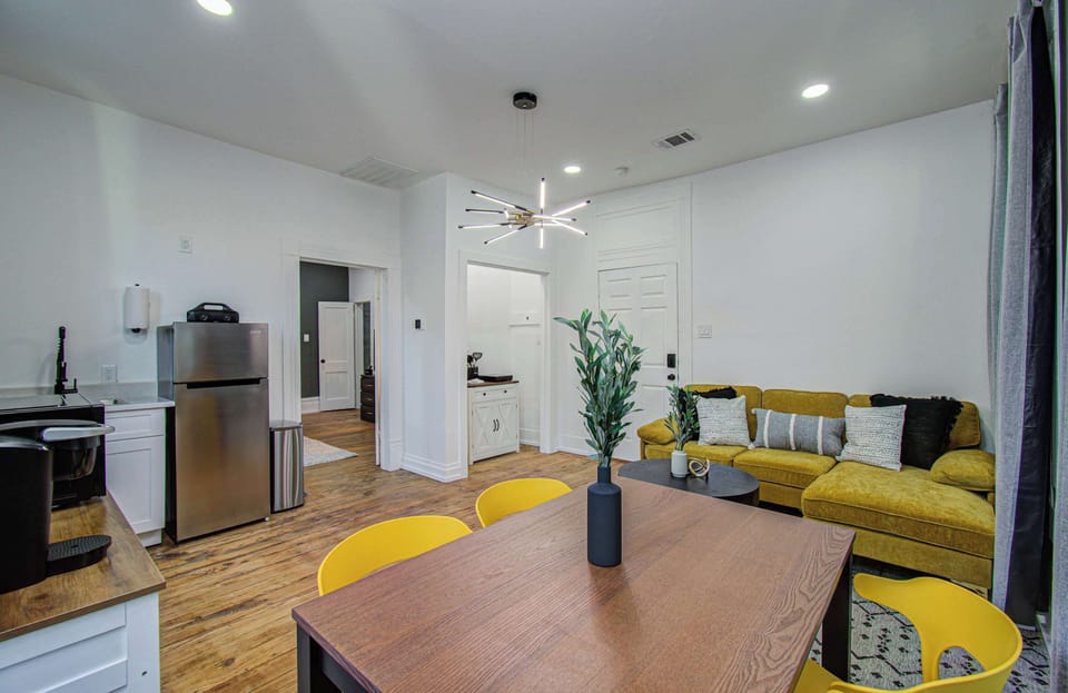 Modern open-concept suite with stylish lounge seating, dining space, and kitchenette—perfect for work or weekend stays.