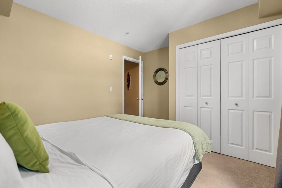 Second bedroom with a queen bed and blackout curtains.