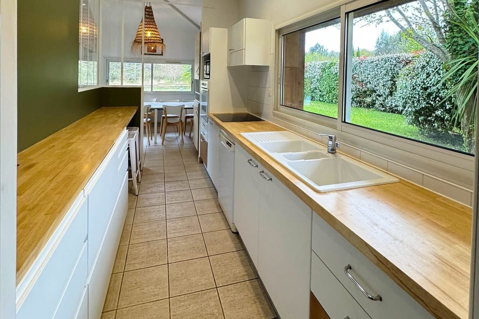 Fully equipped kitchen with wooden countertops — everything you need to cook in, or head out to Le Transat for lunch instead.