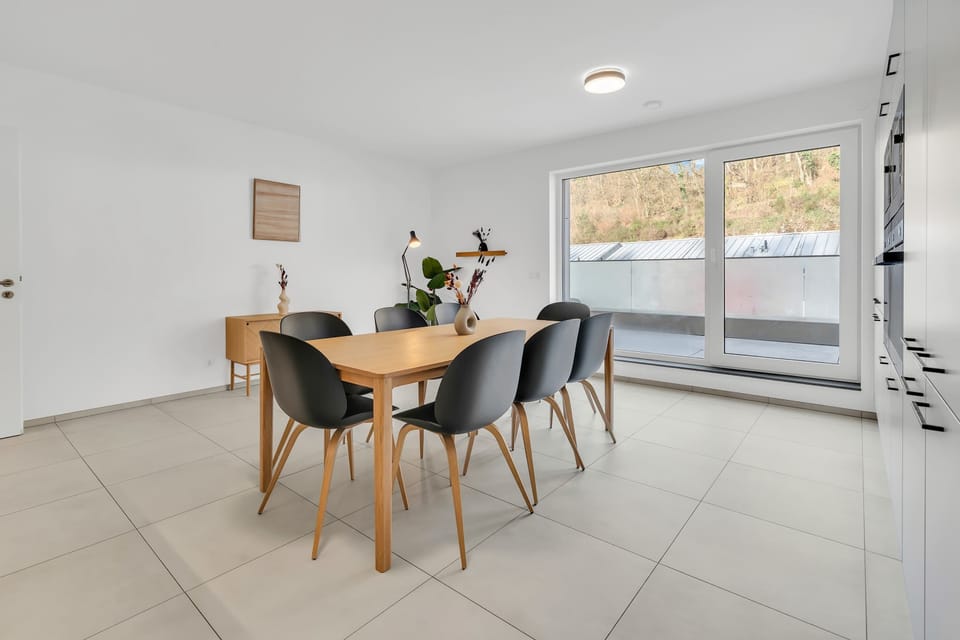 Dining area with large windows and natural light, creating a warm atmosphere.