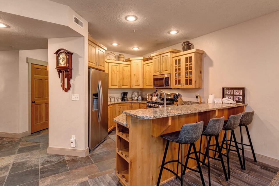 Your fully equipped kitchen includes granite counters, bar seating for four, and custom wood cabinetry with lodge-inspired details.