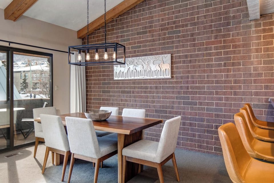 Share meals or board games at your dining table for six beneath modern lighting and brick walls.