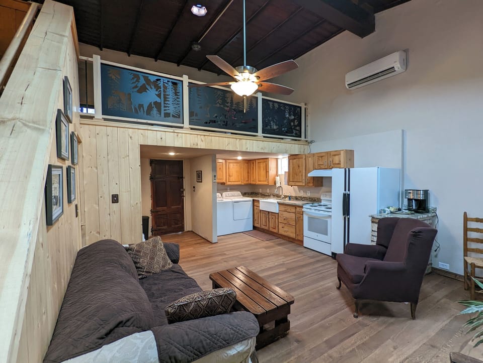 interior, indoor, coffee and or coffee maker, climate control, oven, couch, refrigerator, living area, television, stovetop, kitchen visible