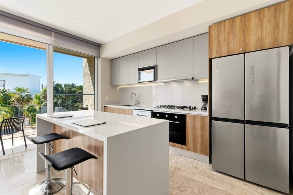 Enjoy cooking in the modern kitchen featuring a kitchen island, microwave, coffee maker, and 6-burner stove with a full-size oven. Take in the beautiful tropical views while preparing meals or gathering around the island with family and friends.