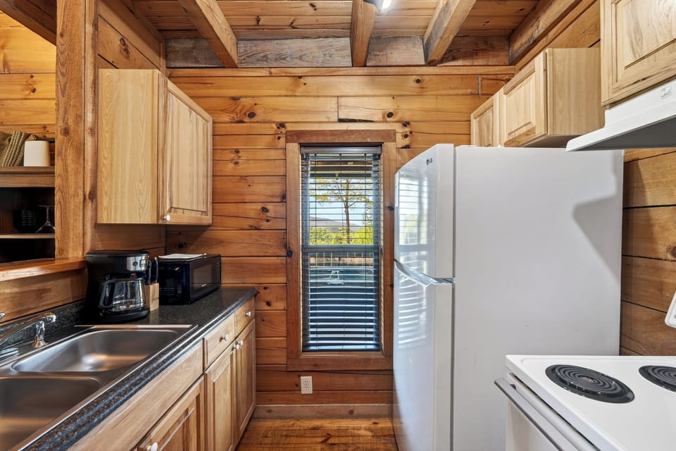 A charming, cabin-style kitchen with rustic wood finishes and a breakfast bar—perfect for easy mornings and casual meals. (Elijah's Cabin)