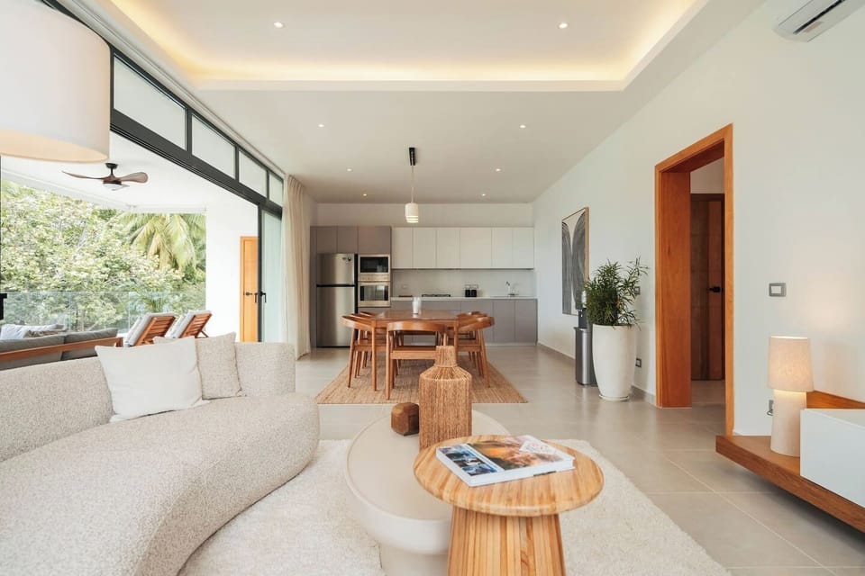 Open-concept living, dining, and kitchen area with a comfortable sofa, dining table, and fully equipped kitchen.