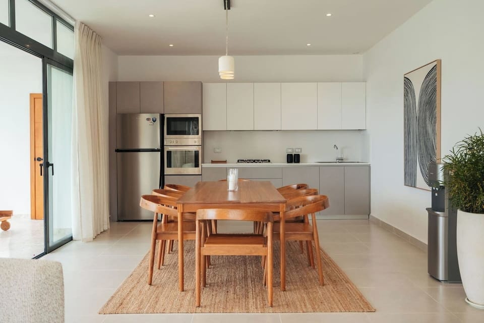 Spacious dining area with seating for six and a fully equipped kitchen, perfect for shared meals and gatherings.
