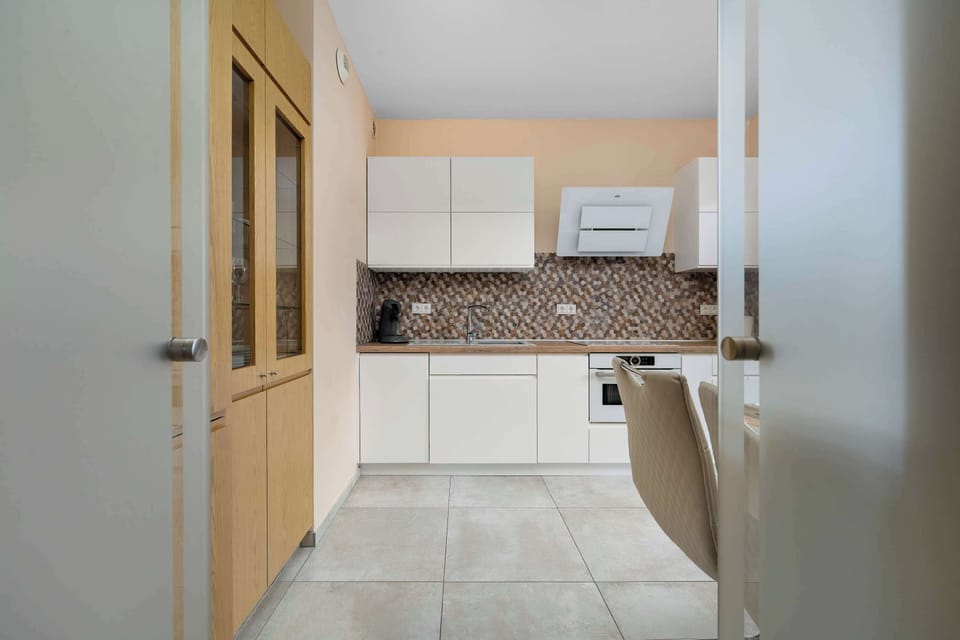 A compact kitchen with white cabinetry and a small dining area. It provides everything needed for convenient meal preparation.