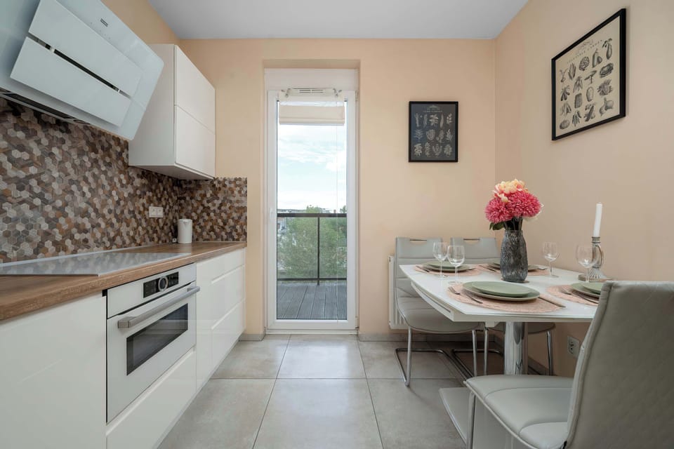 A small dining area next to a modern kitchen. It is perfect for shared meals in a compact space.