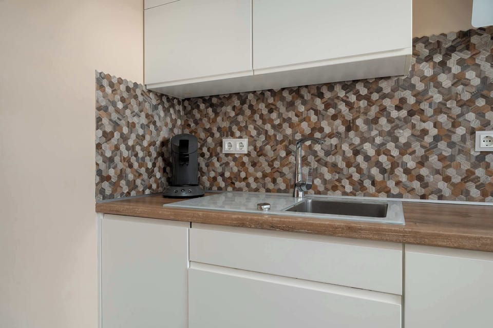A close-up of a modern kitchen countertop and backsplash. The design is clean and stylish.