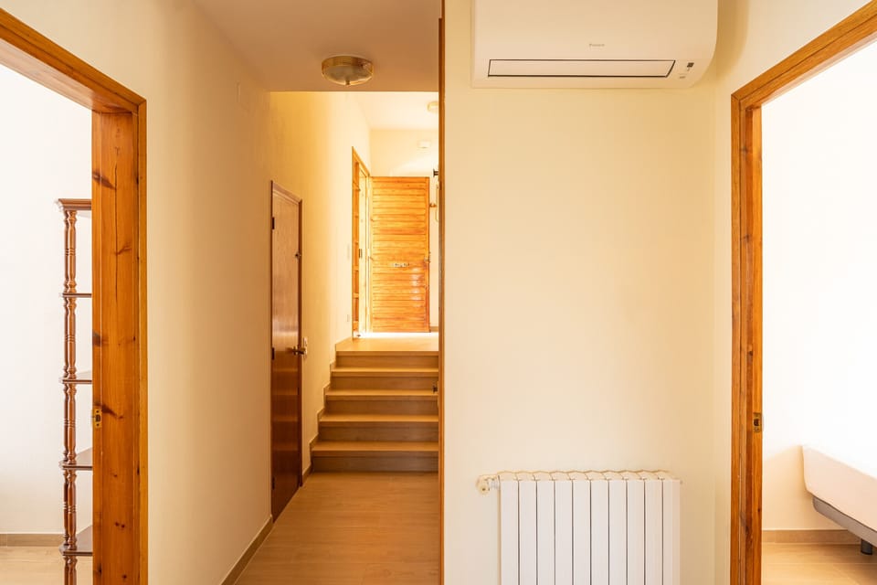 Upper floor corridor at Majordoms Velo with a smart thermostat and air conditioning that keeps all four bedrooms cool. The bedrooms connect here — a practical layout for groups with easy access to every room.