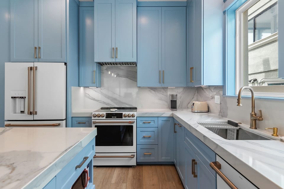 Chef-inspired kitchen with marble-style backsplash, gold hardware, and abundant counter space for entertaining
