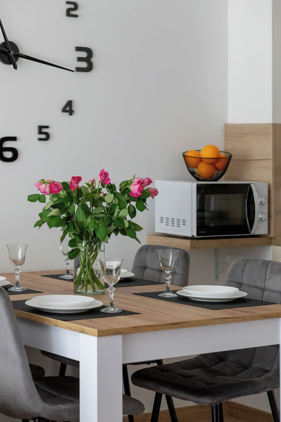 Dining table detail with flowers and decorative wall clock