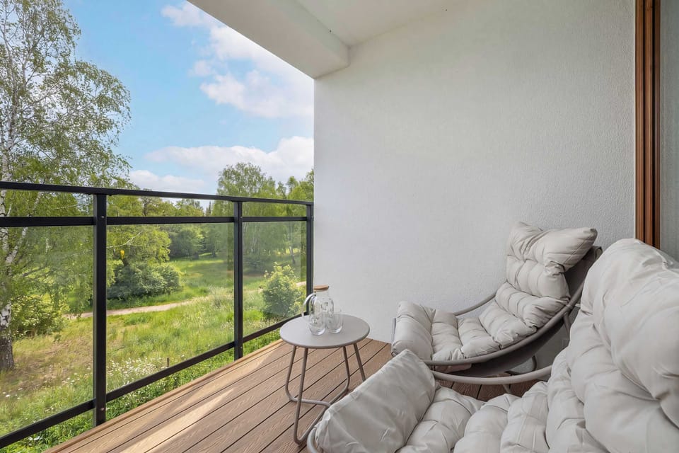 Sunny balcony with lounge chair and green outdoor view