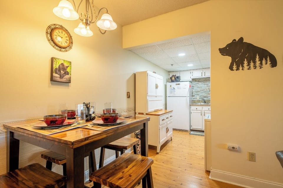 Gather around your rustic dining table for meals and conversation, while the fully-equipped kitchen awaits your culinary adventures. Warm wood tones and charming mountain decor set a welcoming, homey tone.