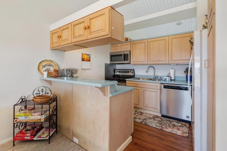 Picture yourself cooking your favorite meals in this bright, fully-equipped kitchen. Natural wood cabinetry, modern stainless appliances, and a handy breakfast bar create your perfect home-away-from-home cooking space.