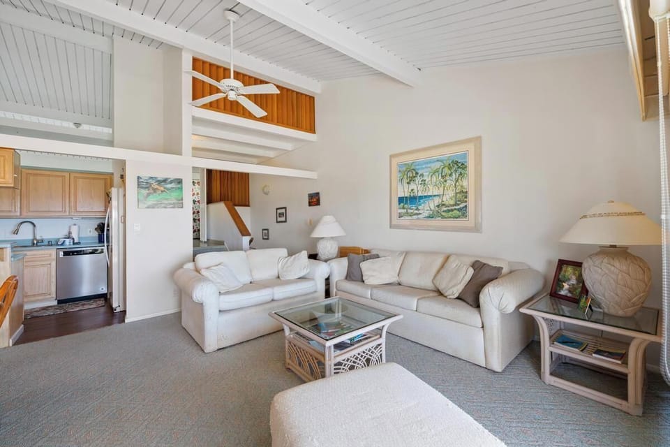 Sink into plush sofas beneath soaring vaulted ceilings, where tropical breezes from the ceiling fan and beach-inspired art set the tone for your perfect island escape.