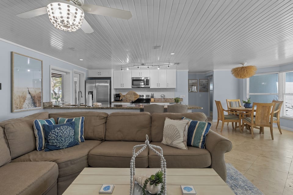 Relax in your spacious open-concept living area where coastal charm meets modern comfort. The fully equipped kitchen and dining space invite you to gather, while the soft palette and airy design create a serene retreat.