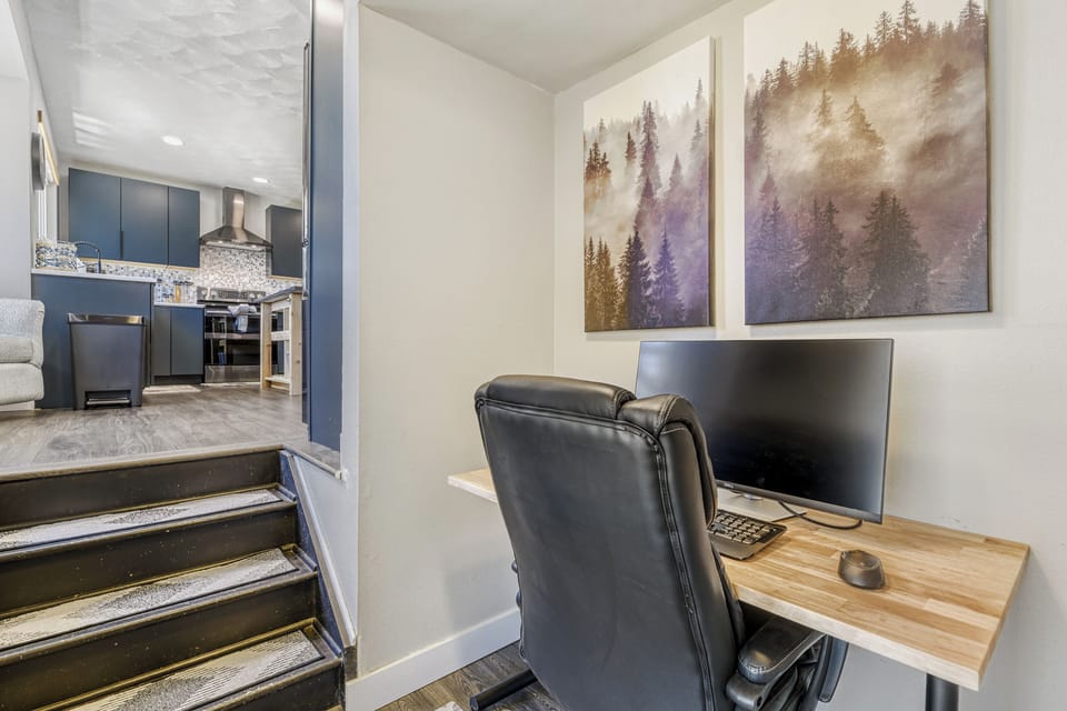 Your dedicated workspace features a comfortable desk setup with serene forest artwork, perfect for staying connected or planning your next adventure.