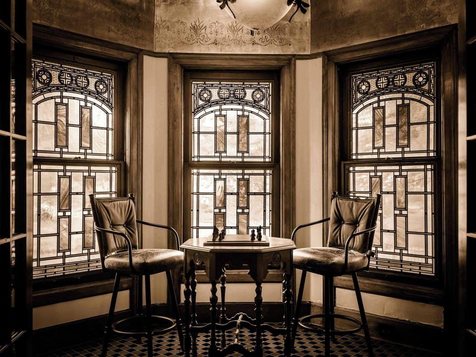 Stunning bay window alcove w/ original wood trim — a moody, light-filled retreat.
