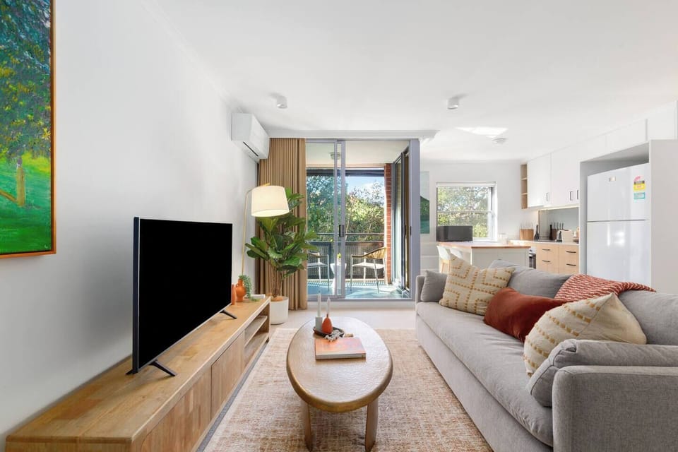 Sink into the cosy living area after a day exploring Surry Hills, where soft natural light, warm textures, and streaming entertainment create an easy space to relax and recharge.