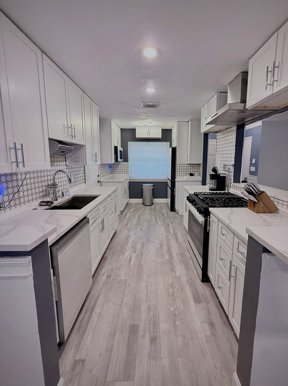 Bright modern galley kitchen with sleek finishes and gas range