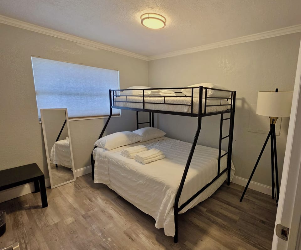 Bright bunk room with full-over-twin beds, mirror, and modern touches