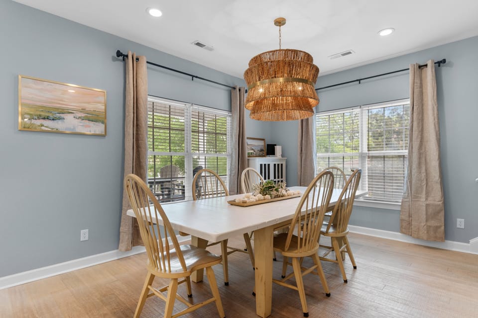 Gather around this bright dining space where soft blue walls and warm wood tones create the perfect setting for your morning coffee or evening meals together.