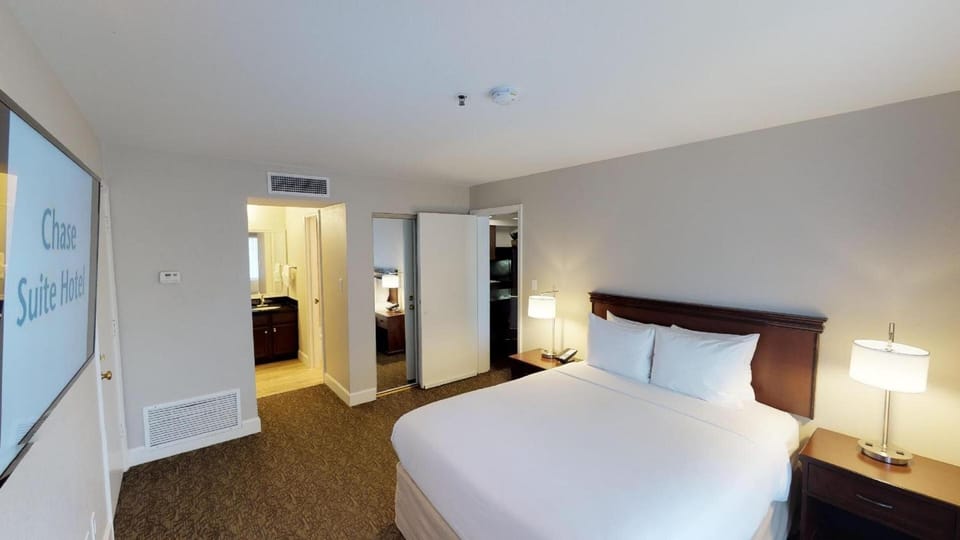 Stretch out comfortably in a spacious bedroom with cozy bedside lighting.