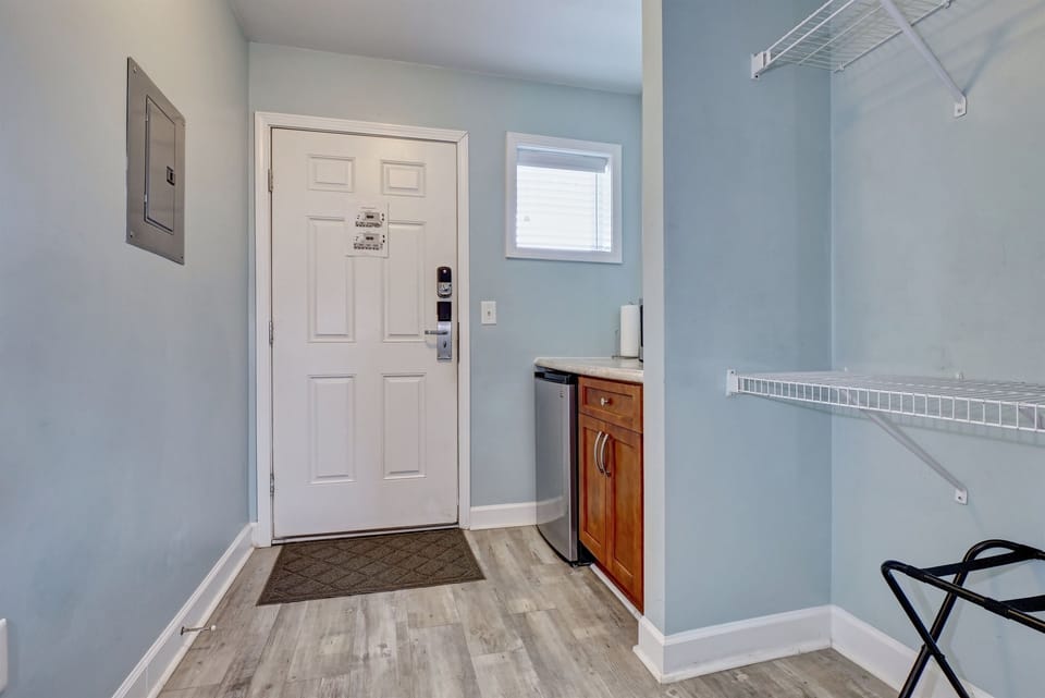 Welcoming entryway with convenient kitchenette featuring a mini fridge, counter space, and storage: perfect for quick meals and beach snacks
