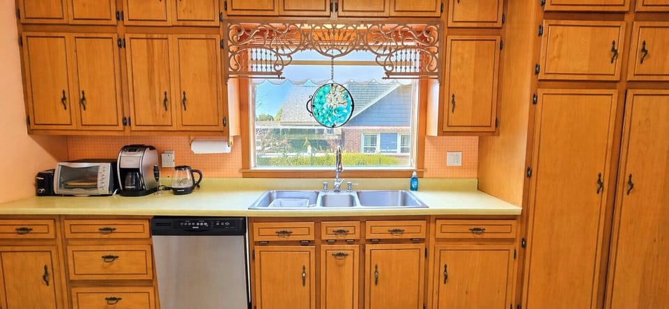 Cozy Galley Kitchen Equipped with Essentials. Electric Range, Microwave, Dishwasher.