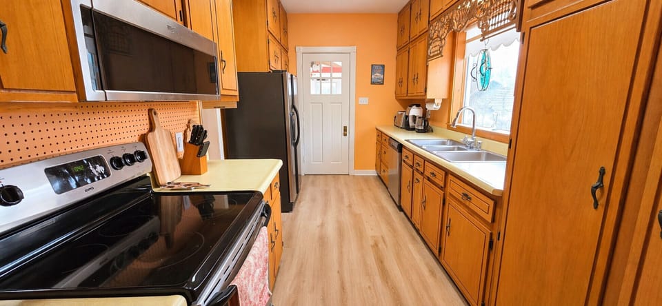 Cozy Galley Kitchen Equipped with Essentials. Electric Range, Microwave, Dishwasher.