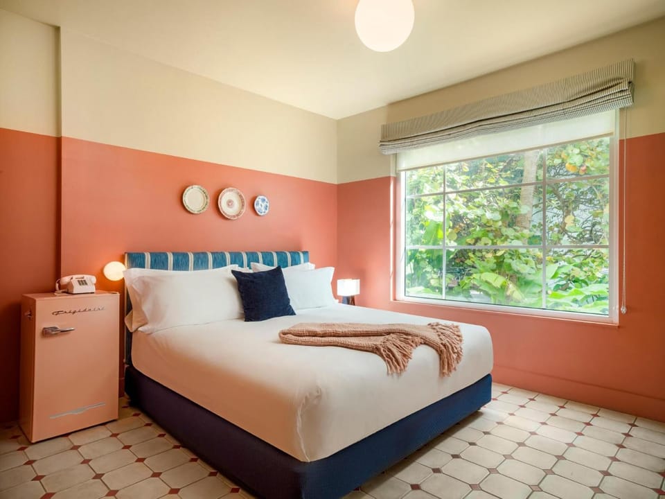 Unwind in crisp linens beside a lush garden window.