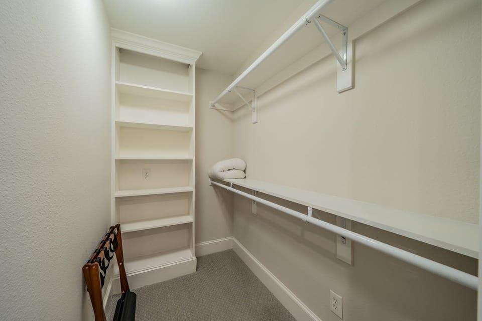 Additional storage closet with built-in shelving and hanging space for easy orga