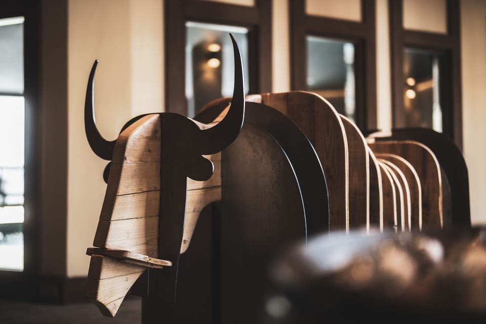 Carved wood details and warm amber lighting carry the Kashmir-inspired theme through the shared lounge spaces.
