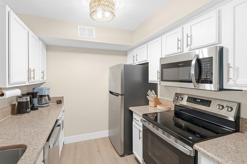 Kitchen - featuring oven, range, fridge, dishwasher, microwave, stocked with all cooking/serving essentials and a coffee bar 
