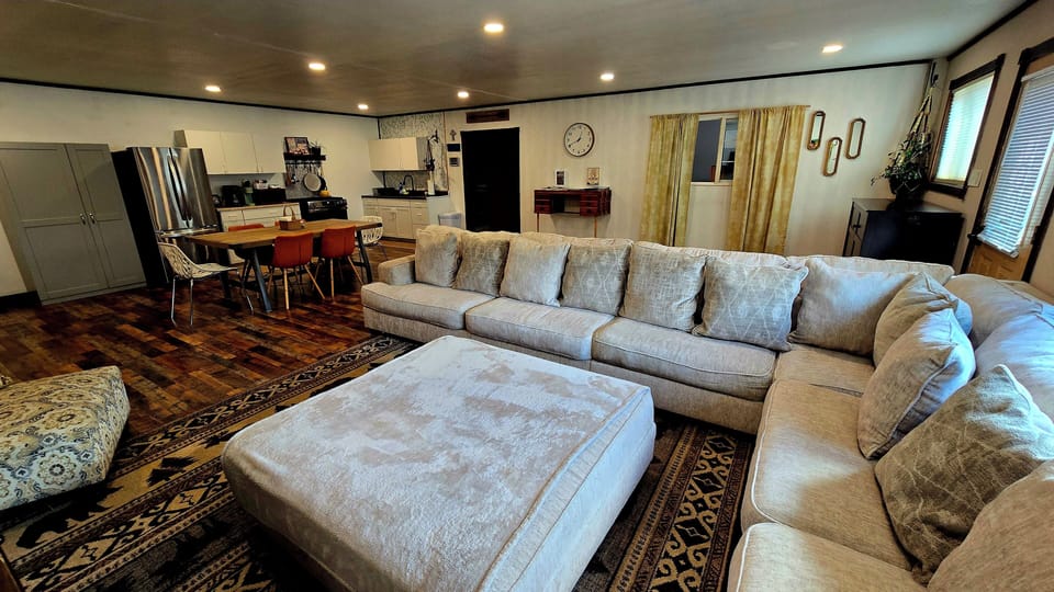 microwave, kitchen visible, interior, indoor, oven, couch, refrigerator, living area, desk, stovetop, dining table