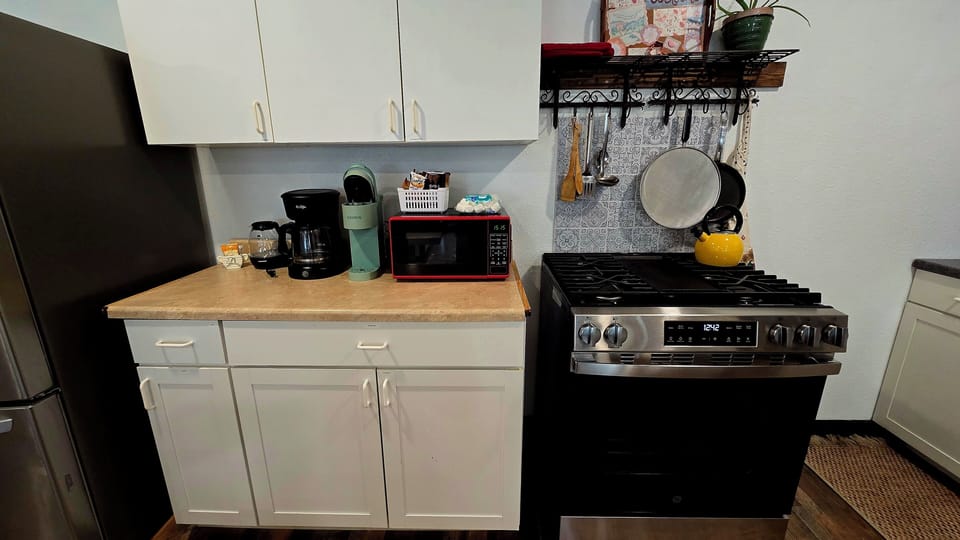 microwave, kitchen visible, indoor, coffee and or coffee maker, kitchen, oven, refrigerator, stovetop