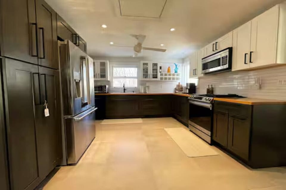 Fully equipped chef's kitchen featuring sleek dark cabinets and modern appliance