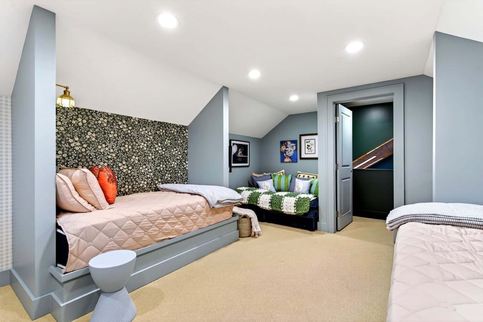 Upper-level bunkroom with 4 twin beds, accessed by a spiral staircase from the living room